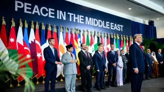 Des dirigeants présents devant un mur avec le texte "PAIX AU MOYEN-ORIENT" et des drapeaux.