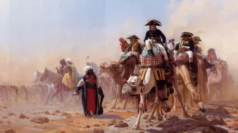 L'image représente un groupe de cavaliers sur des chevaux et des chameaux, se déplaçant à travers un paysage désertique. Les cavaliers portent des costumes traditionnels riches en couleur, souvent ornés de détails. On peut voir de la poussière soulevée par le mouvement, créant une atmosphère de chaleur et d'intensité. L'arrière-plan est flou, suggérant l'immensité du désert. L'ensemble dégage une impression de mouvement et d'aventure.