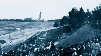 Une foule en bas d'une colline, avec un bâtiment en arrière-plan, scène historique.