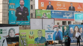 Des panneaux électoraux colorés avec des portraits et des slogans politiques.