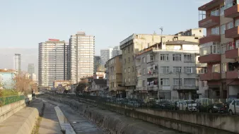 Vue d'une rue avec des immeubles modernes et des bâtiments anciens, le tout au bord d'un canal.