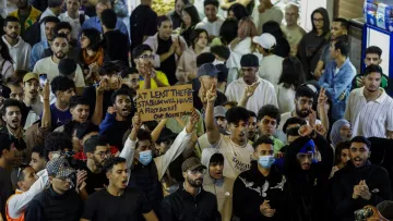 Un groupe de jeunes manifestants agitant des pancartes lors d'un rassemblement animé.