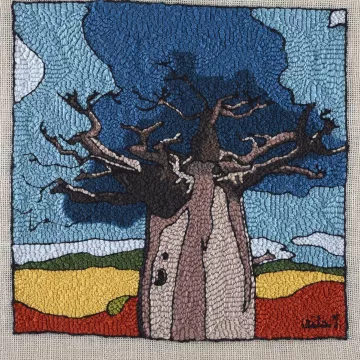 Un grand baobab aux branches nues, sous un ciel bleu, entouré de champs colorés.