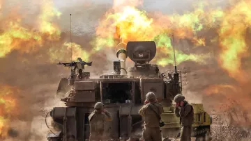 L'image montre un char de combat en action, probablement en train de tirer. Des soldats en uniforme sont présents près du char, occupant des positions de tir ou se préparant à l'action. En arrière-plan, des explosions et des flammes se produisent, créant une atmosphère intense et chaotique. La scène évoque un environnement militaire, avec une ambiance de conflit et de mouvement.