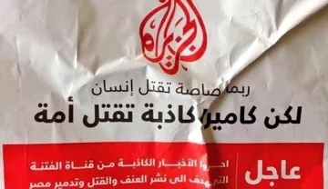 L'image montre une affiche avec du texte en arabe et en français. Elle semble émettre un message urgent, probablement en rapport avec des événements violents ou des conflits. Le design est simple, avec un fond clair et un accent sur le texte, ce qui suggère qu'il s'agit d'une communication importante. Le logo d'Al Jazeera est également visible, ce qui indique que l'affiche pourrait être liée à un rapport ou à des nouvelles diffusées par ce média.