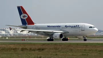 Avion de la compagnie Yemenia avec un design aux couleurs rouge, bleu et blanc sur la piste.