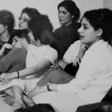 Un groupe de femmes assises, discutant et écoutant attentivement, visages concentrés.