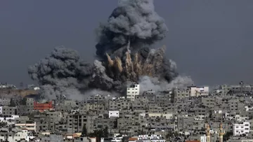 الصورة تظهر مشهدًا لمدينة تعرضت لتفجير، حيث تندلع سحب كثيفة من الدخان الأسود في السماء. يظهر تأثير الانفجار في المباني المحيطة، حيث تبرز آثار الدمار، بينما يبدو أن السماء ملبدة بالغيوم الناتجة عن الانفجار. المدينة تبدو كثيفة البنايات مع تشوهات واضحة نتيجة الأحداث المدمرة.