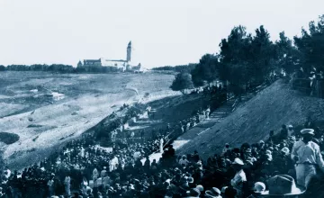 Une foule en bas d'une colline, avec un bâtiment en arrière-plan, scène historique.
