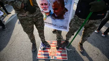 L'image montre des soldats en uniforme militaire debout sur une affiche ou un symbole qui semble représenter des sentiments anti-américains. Ils tiennent des drapeaux ou des bannières, et il y a une image de personnes, probablement des figures politiques ou militaires, sur l'affiche. Le sol est décoré d'une illustration de style artistique, mélangé avec des éléments du drapeau américain, ce qui suggère une forte opinion politique et un contexte de protestation ou de commémoration.