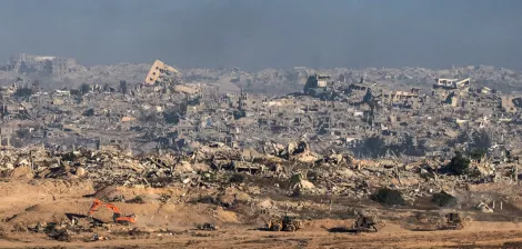 Terrain dévasté avec des bâtiments en ruines et des machines de chantier.