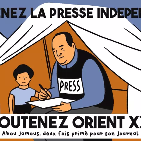 Homme en t-shirt "PRESS" écrit à une table, enfant près de lui, sous une tente.