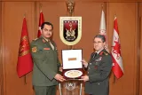 Deux officiers militaires échangent un cadeau cérémoniel dans un bureau officiel.