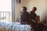 Deux hommes assis sur un lit, l