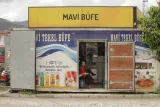 Un petit magasin avec une femme assise à l