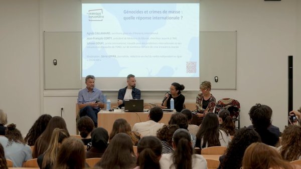 Table ronde discutant des génocides et de la réponse internationale, avec quatre intervenants.