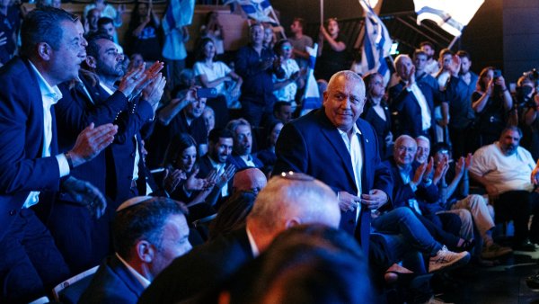 Un homme souriant au milieu d'une foule applaudissant lors d'un événement.