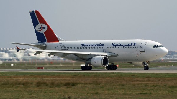 Avion de la compagnie Yemenia avec un design aux couleurs rouge, bleu et blanc sur la piste.