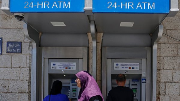 Deux distributeurs automatiques de billets, avec des utilisateurs devant.