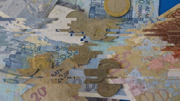 Des billets et pièces de monnaie, en désordre et légèrement flous.