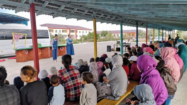 Un groupe de personnes assiste à un spectacle sous un abri.