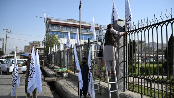 Des hommes installent des drapeaux blancs près d'une clôture en ville.